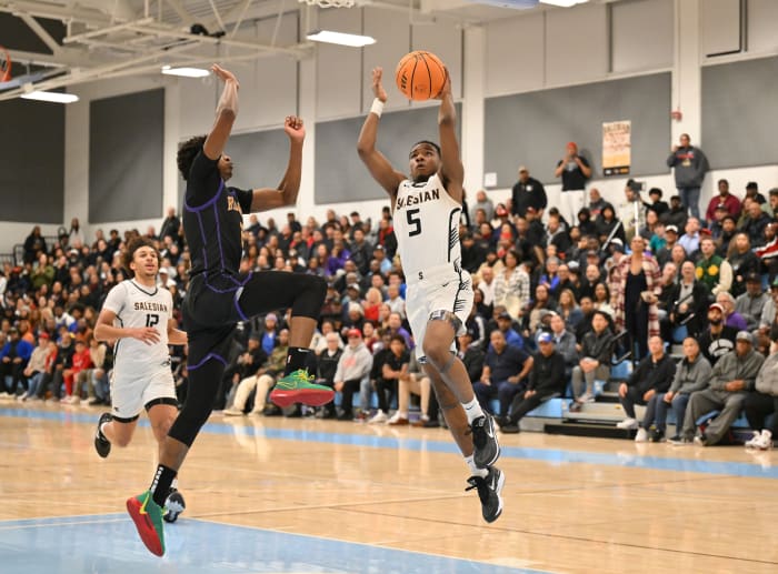 Salesian's Isaiah Davis (5) goes in toward the hoop under heavy duress.